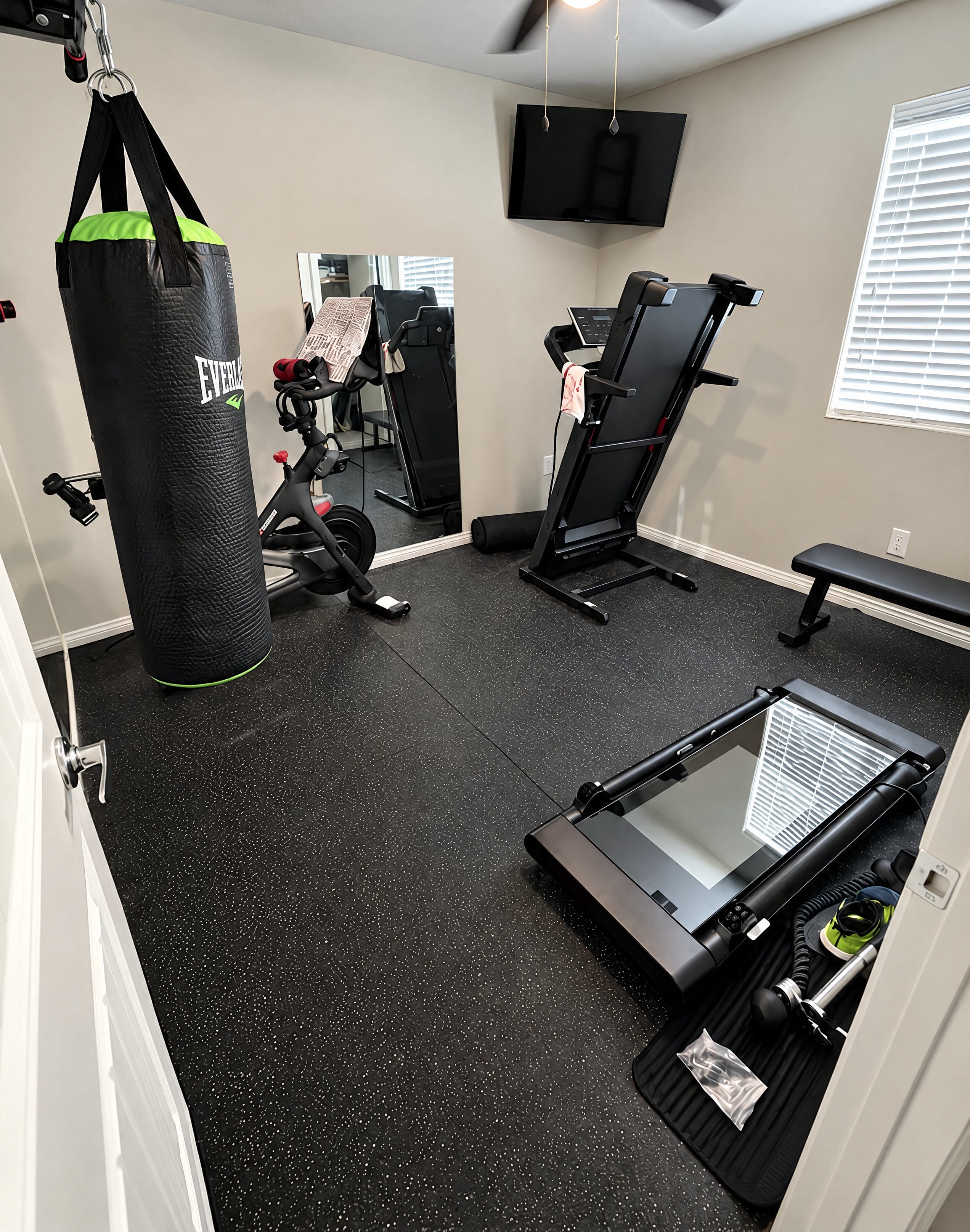 Home gym with equipment set up and a wall-mounted TV